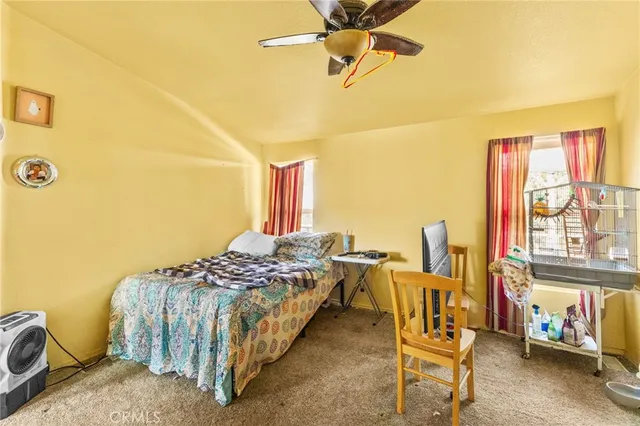 a bedroom with a bed and large windows