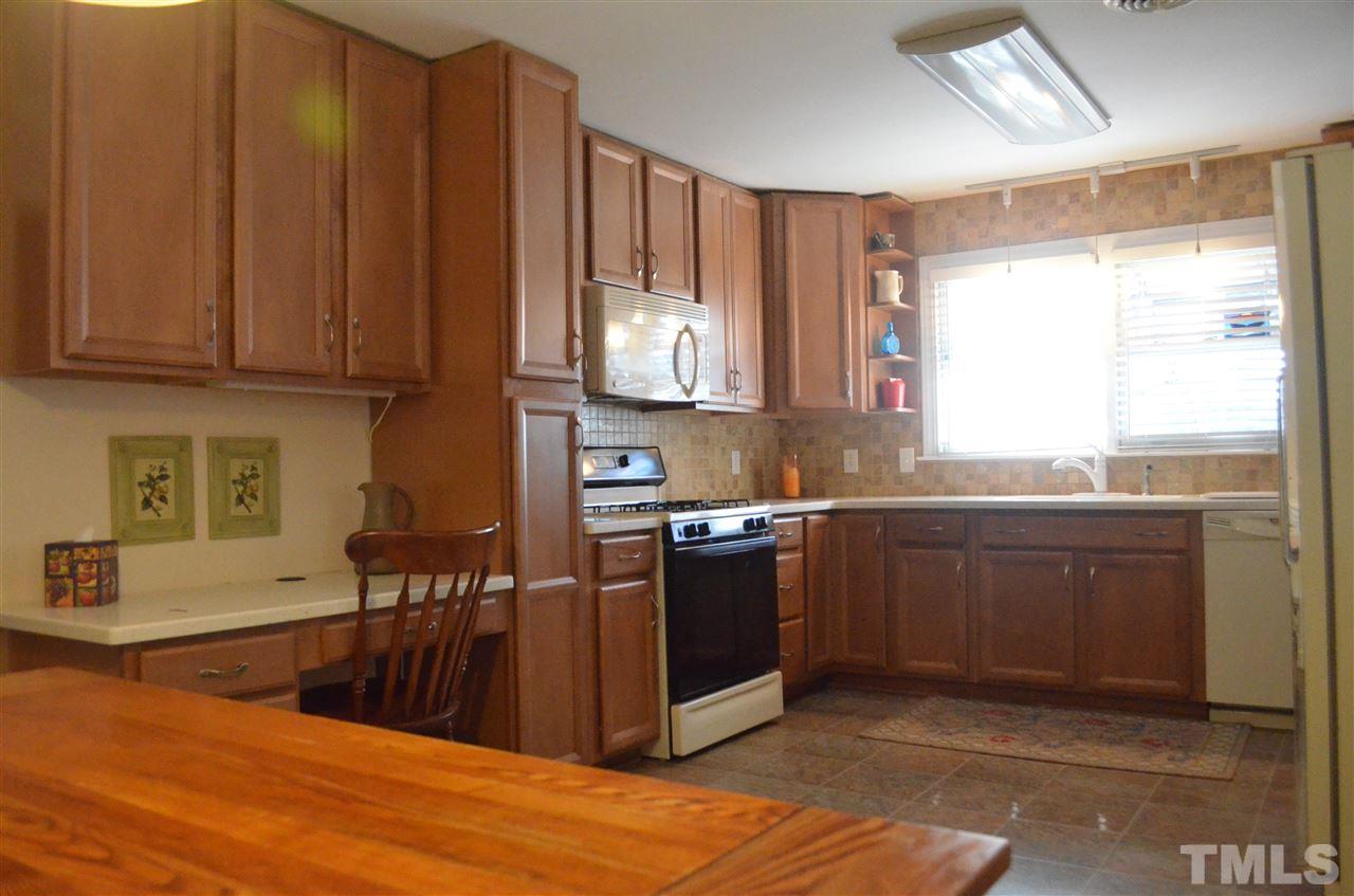5311 Alpine Drive Raleigh, NC 27609 - Photo 7 of 25 a kitchen with stainless steel appliances granite countertop a stove a sink and a microwave