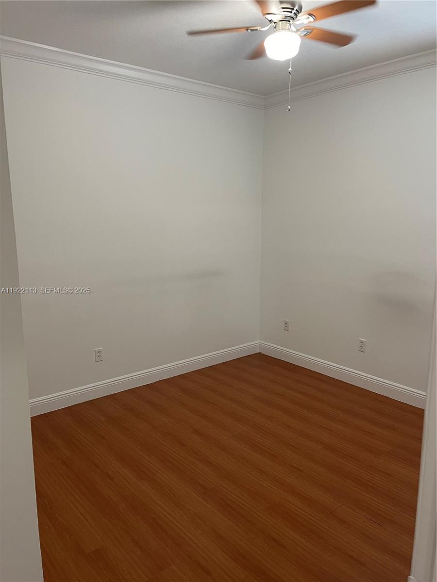 425 Northwest 135th Street North Miami, FL 33168 - Photo 8 of 12 an empty room with wooden floor and fan