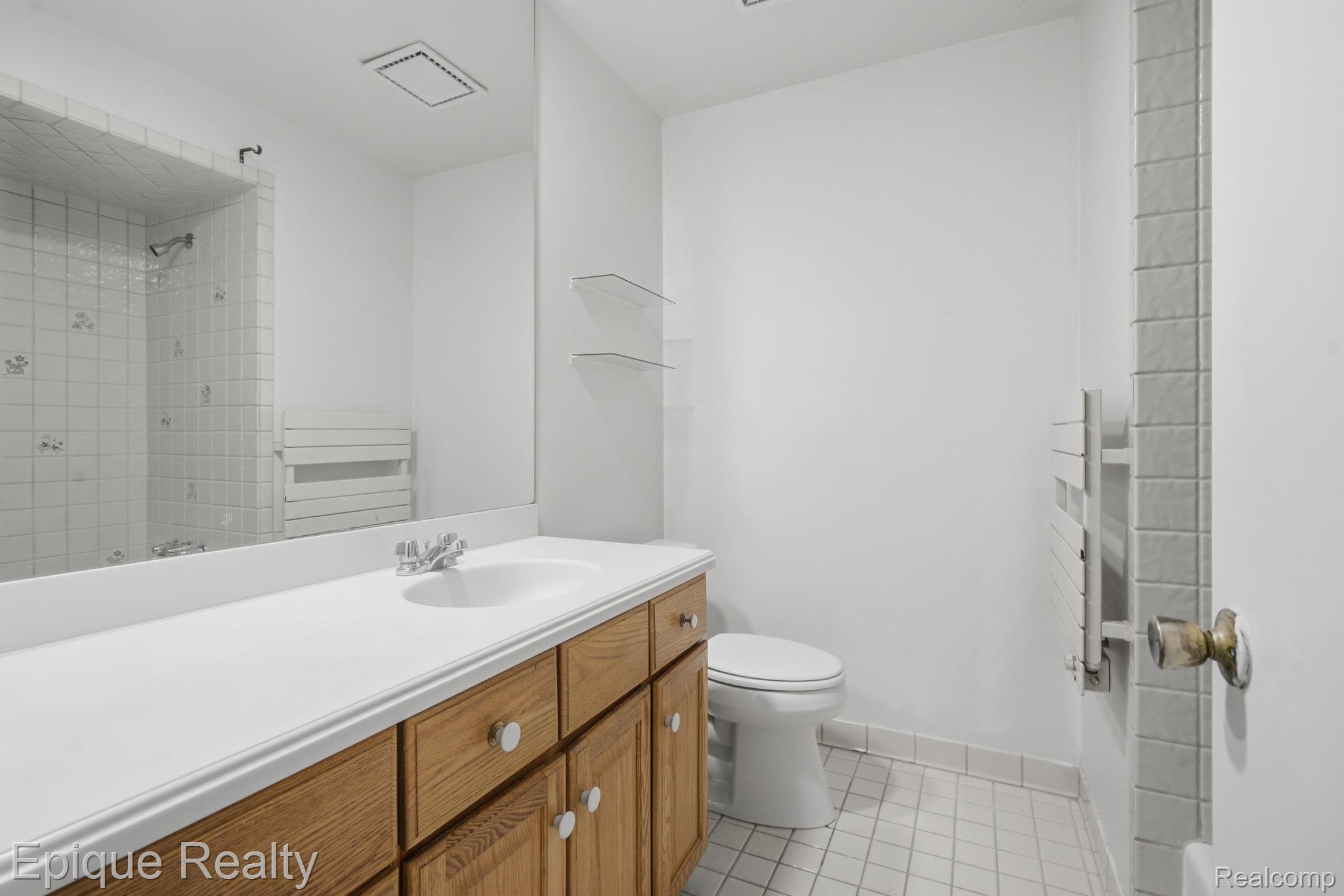 3895 Old Creek Road Troy, MI 48084 - Photo 18 of 23 Bathroom featuring vanity, light tile patterned floors, a shower, and radiator heating unit
