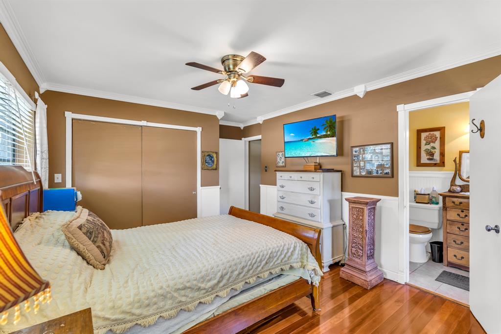 1931 Northeast 27th Street Lighthouse Point, FL 33064 - Photo 23 of 28 a bedroom with a bed dresser and a flat tv screen