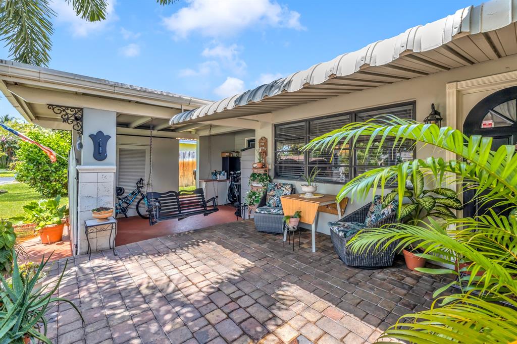 1931 Northeast 27th Street Lighthouse Point, FL 33064 - Photo 10 of 28 a view of a patio with table and chairs potted plants and floor to ceiling window