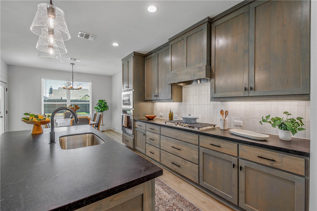 5010 Acadia Loop Bryan, TX 77802 - Photo 13 of 21 a kitchen with sink cabinets and chandelier