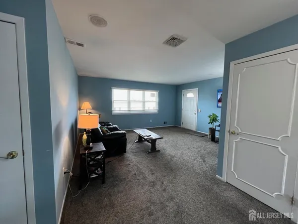a spacious bedroom with a bed and a chandelier
