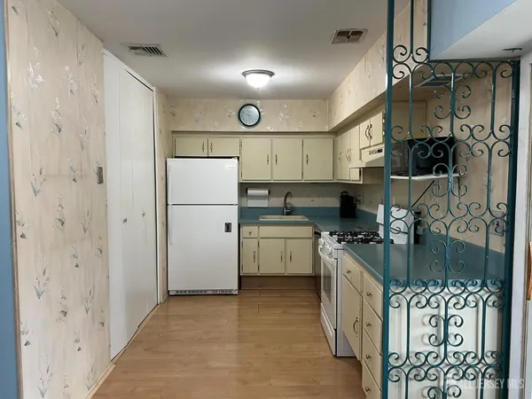 a white stove top oven sitting inside of a kitchen