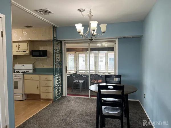 a living room with furniture and a refrigerator