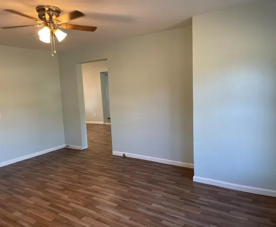 a view of an empty room with wooden floor