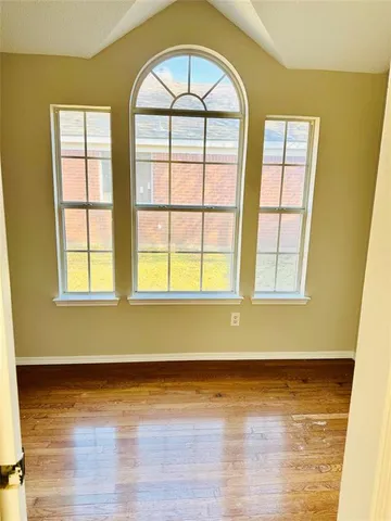 a view of a room with wooden floor and a window