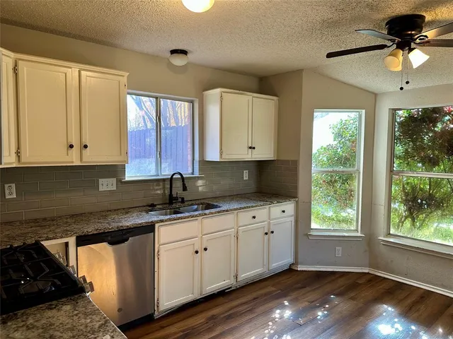 a kitchen with a sink window and cabinets