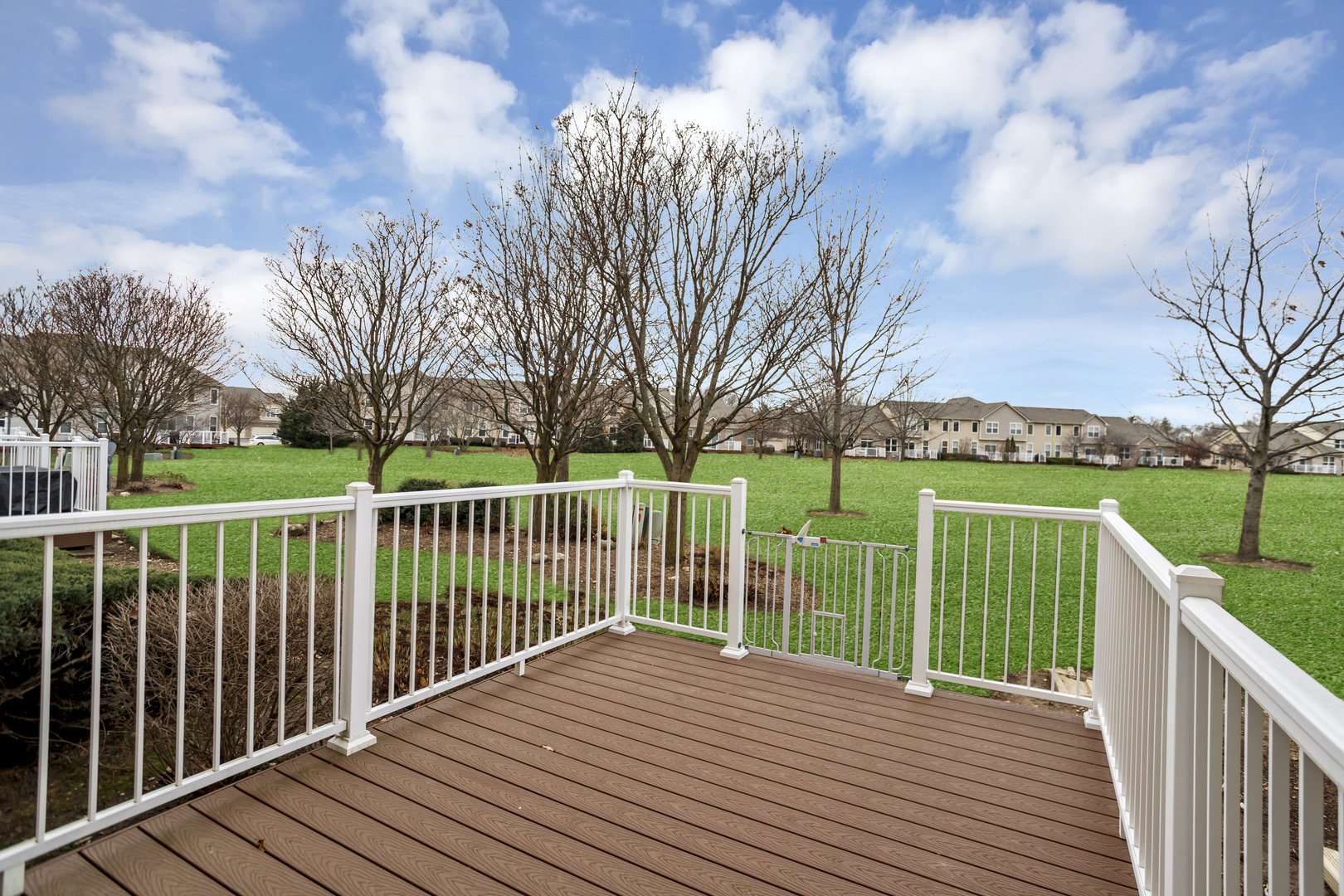 902 Oak Ridge Boulevard Elgin, IL 60120 - Photo 33 of 35 a view of a deck with wooden floor and fence with a trees in the background