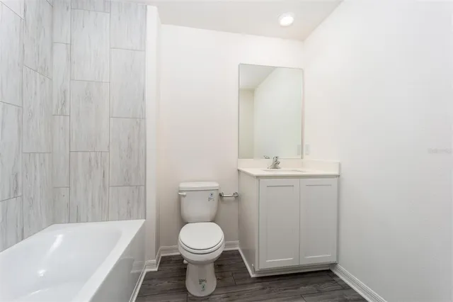 a bathroom with a toilet a sink a mirror and bathtub