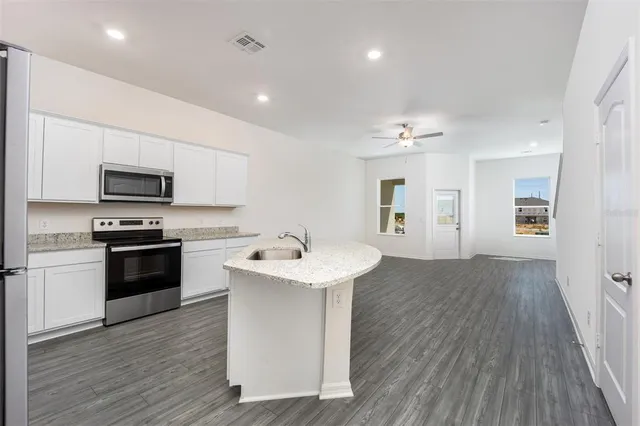 a kitchen with a sink appliances and cabinets