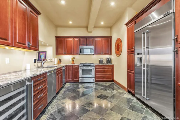 a open kitchen with stainless steel appliances granite countertop a stove a sink and a dining table view