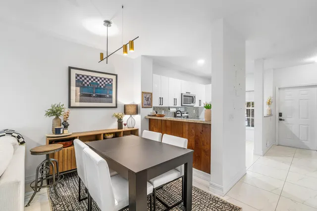 a kitchen with a table chairs refrigerator and cabinets
