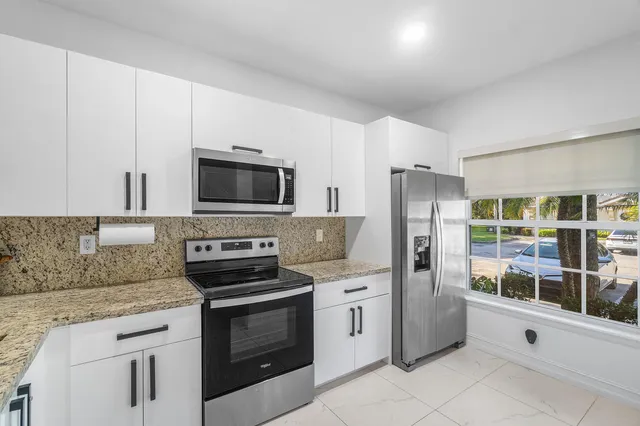 a kitchen with stainless steel appliances granite countertop a stove a refrigerator and a sink