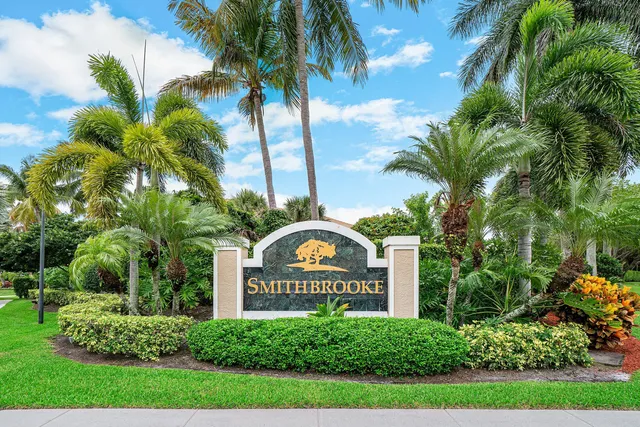 a view of a park that has a sign board and palm trees