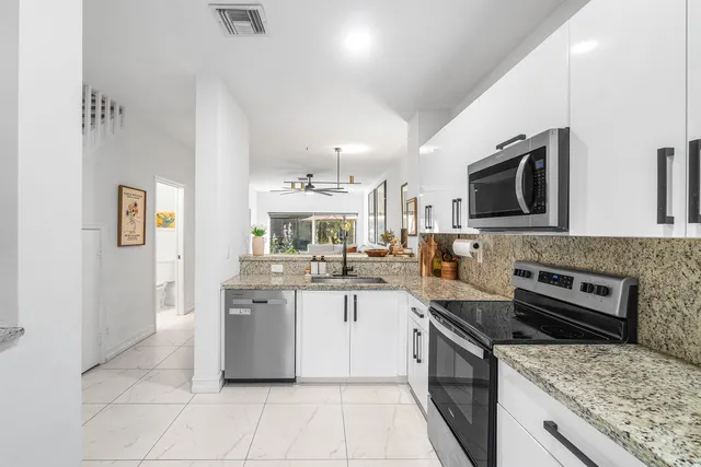 a kitchen with stainless steel appliances granite countertop a sink and stove top oven