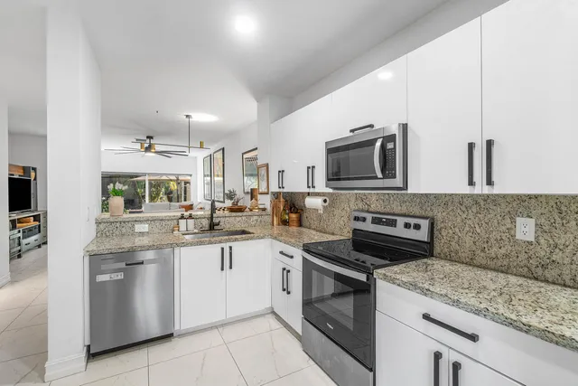 a kitchen with stainless steel appliances granite countertop a sink and stove top oven