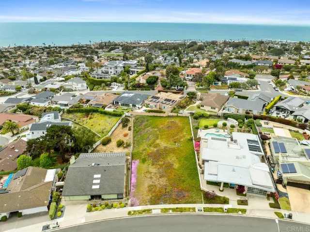 an aerial view of residential houses with outdoor space and ocean view