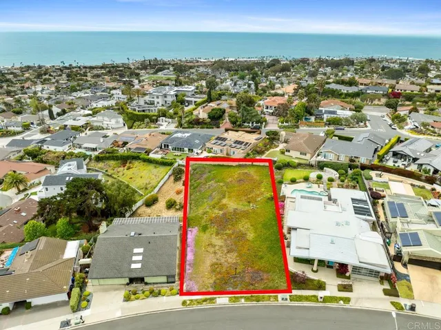 an aerial view of residential houses with outdoor space and ocean view