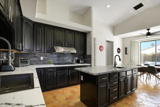 a kitchen with granite countertop a sink dishwasher stove and cabinets