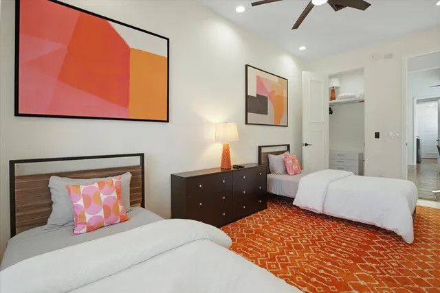 a bedroom with a bed and lamp on dresser