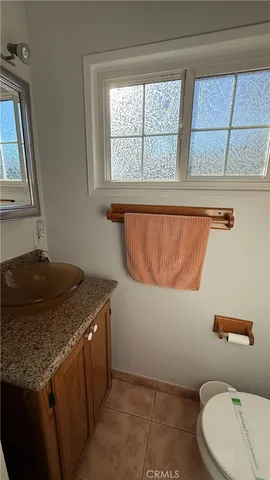 a bathroom with a granite countertop sink and a toilet