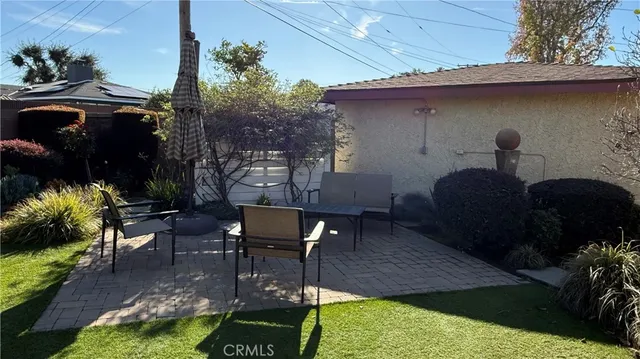 a view of a patio with table and chairs potted plants and floor to ceiling window