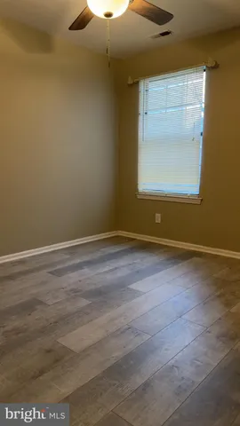 a view of a room with wooden floor and a window