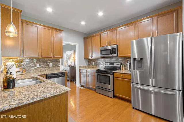 a kitchen with stainless steel appliances granite countertop a refrigerator stove and sink