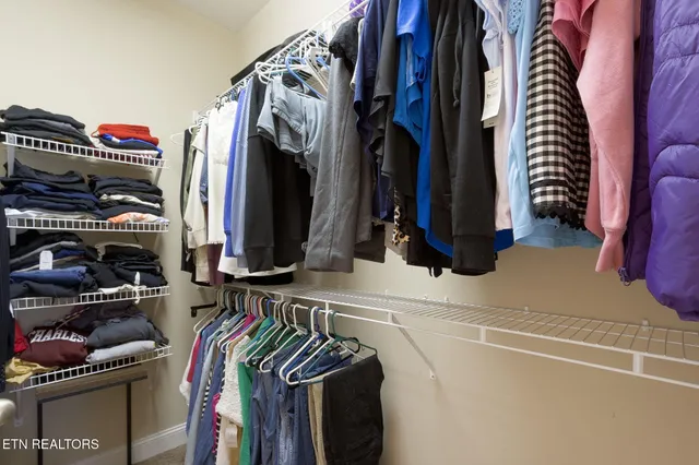 a view of walk in closet with clothes and shoes