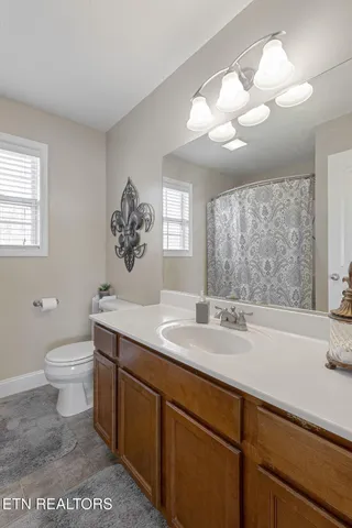a bathroom with a sink a toilet and a large mirror