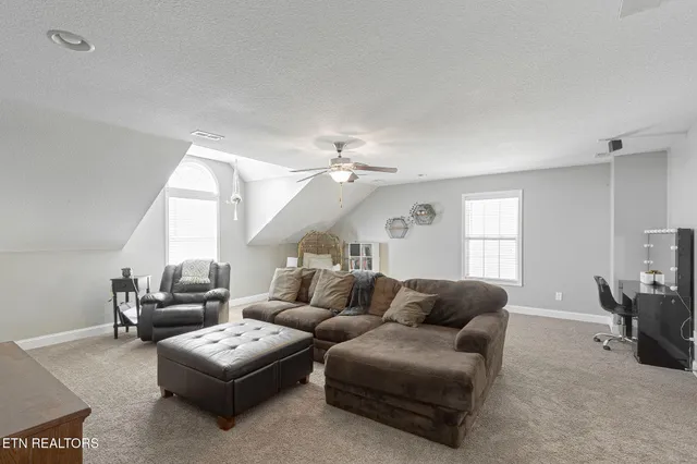 a living room with furniture ceiling fan and a window