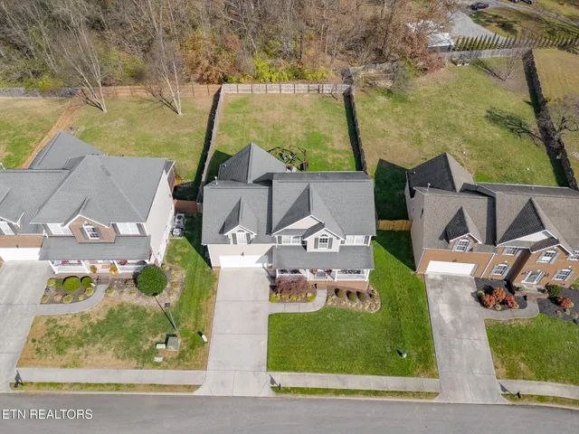an aerial view of a house with a garden and covered with trees