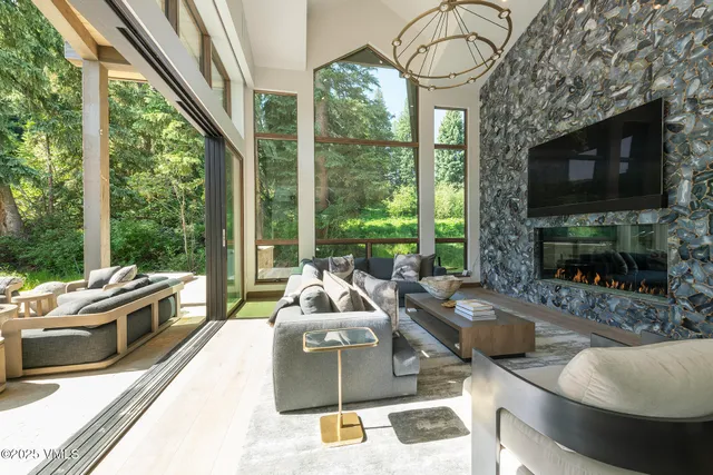a living room with furniture a flat screen tv and a floor to ceiling window