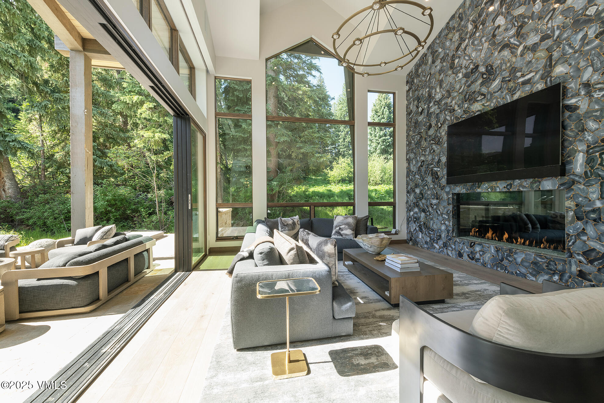 187 Elk Track Road Beaver Creek, CO 81620 - Photo 6 of 19 a living room with furniture a flat screen tv and a floor to ceiling window