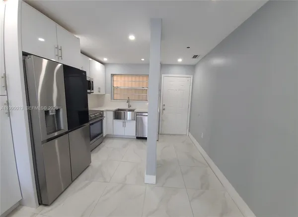a kitchen with stainless steel appliances a refrigerator and microwave