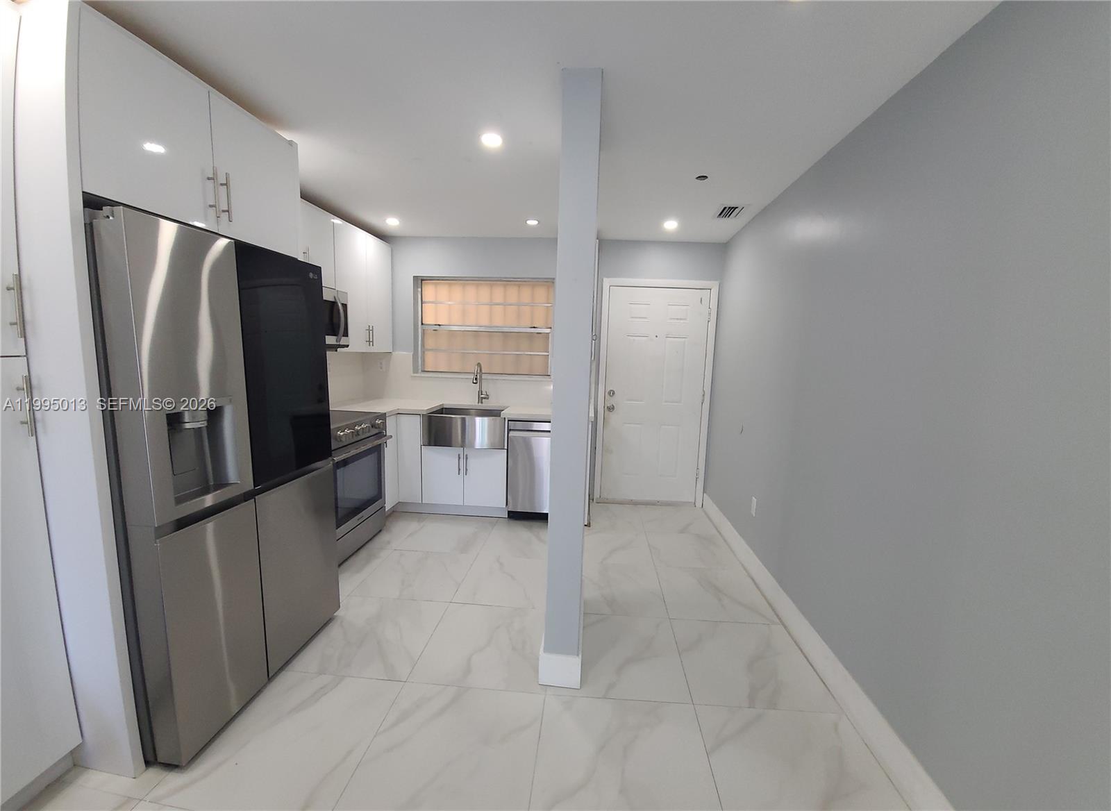 a kitchen with stainless steel appliances a refrigerator and microwave