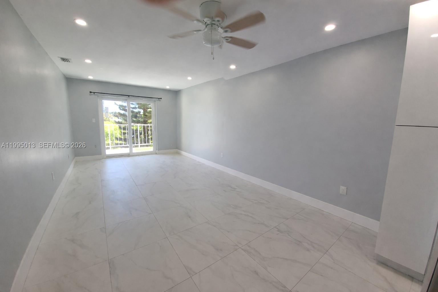 453 Southwest 2nd Street, Unit 306C Miami, FL 33130 - Photo 3 of 18 an empty room with windows and ceiling fan