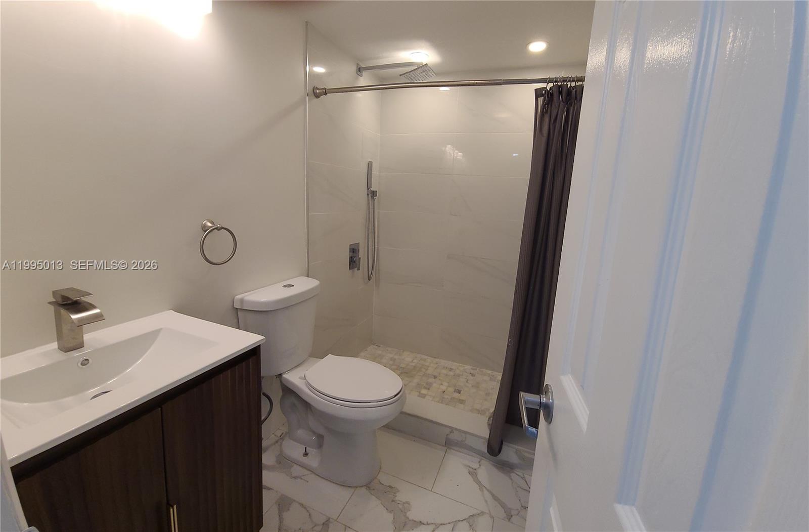 453 Southwest 2nd Street, Unit 306C Miami, FL 33130 - Photo 7 of 18 a bathroom with a sink toilet and shower