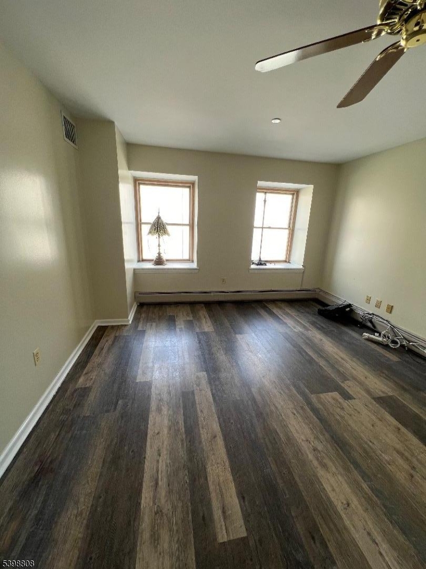 22 South Street, Unit 5 New Providence, NJ 07974 - Photo 4 of 12 an empty room with wooden floor and windows
