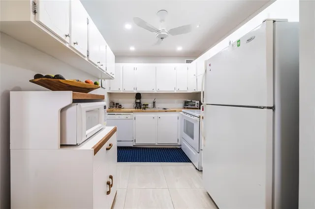 a kitchen with cabinets and white stainless steel appliances
