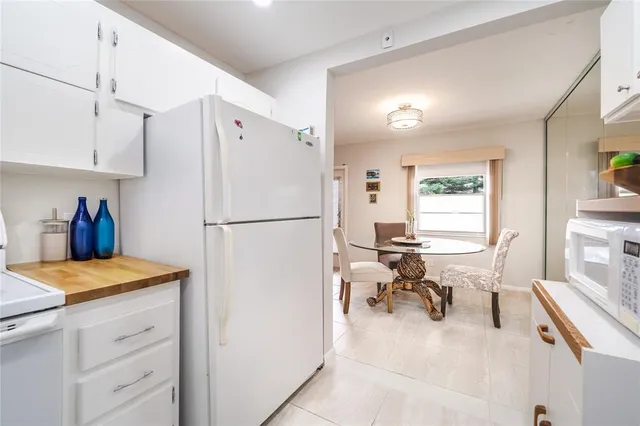 a kitchen with a refrigerator a white stove top oven a sink dishwasher and a refrigerator with wooden floor