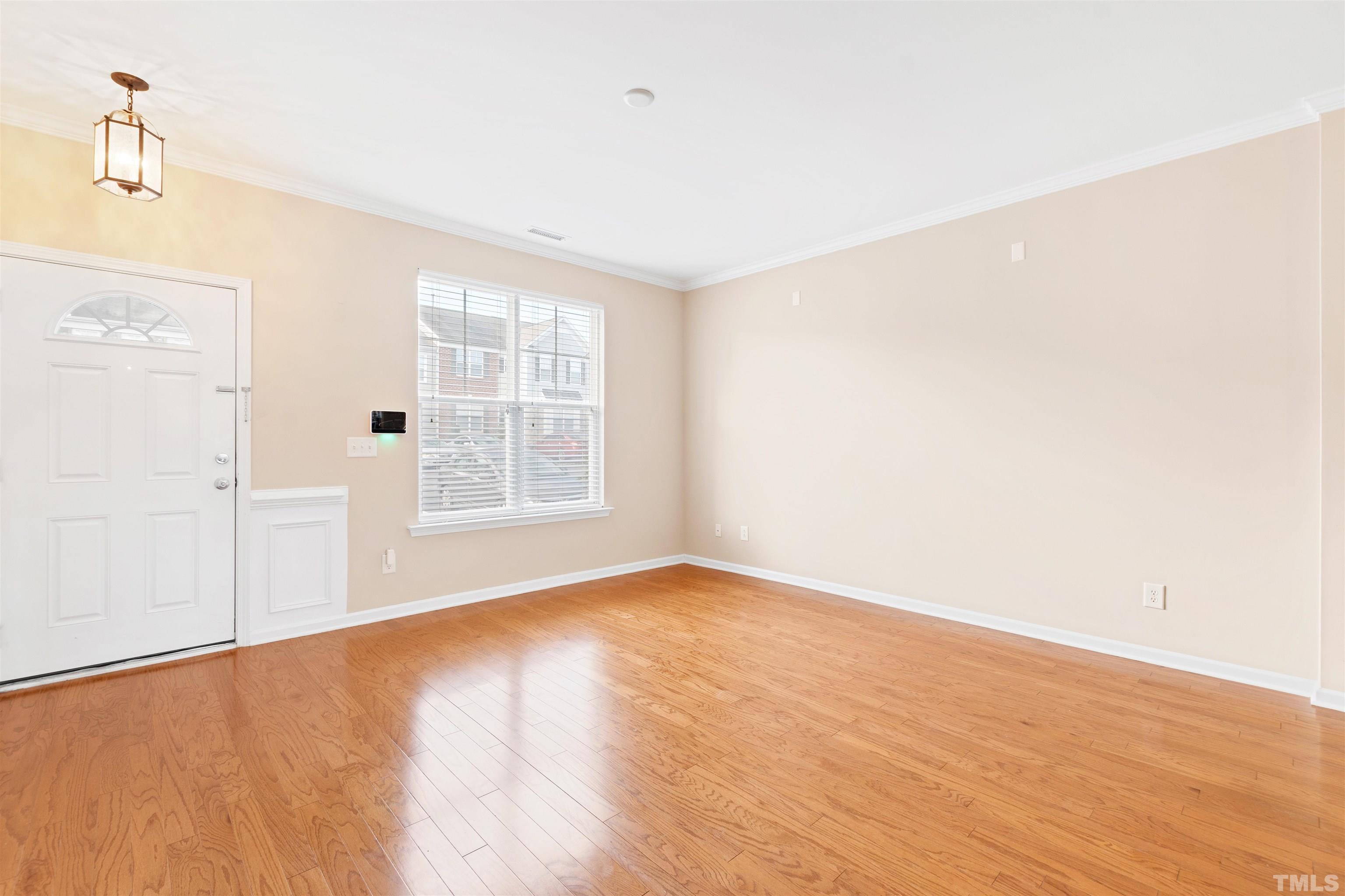 2962 Casona Way Raleigh, NC 27616 - Photo 2 of 40 a view of an empty room with wooden floor and a window