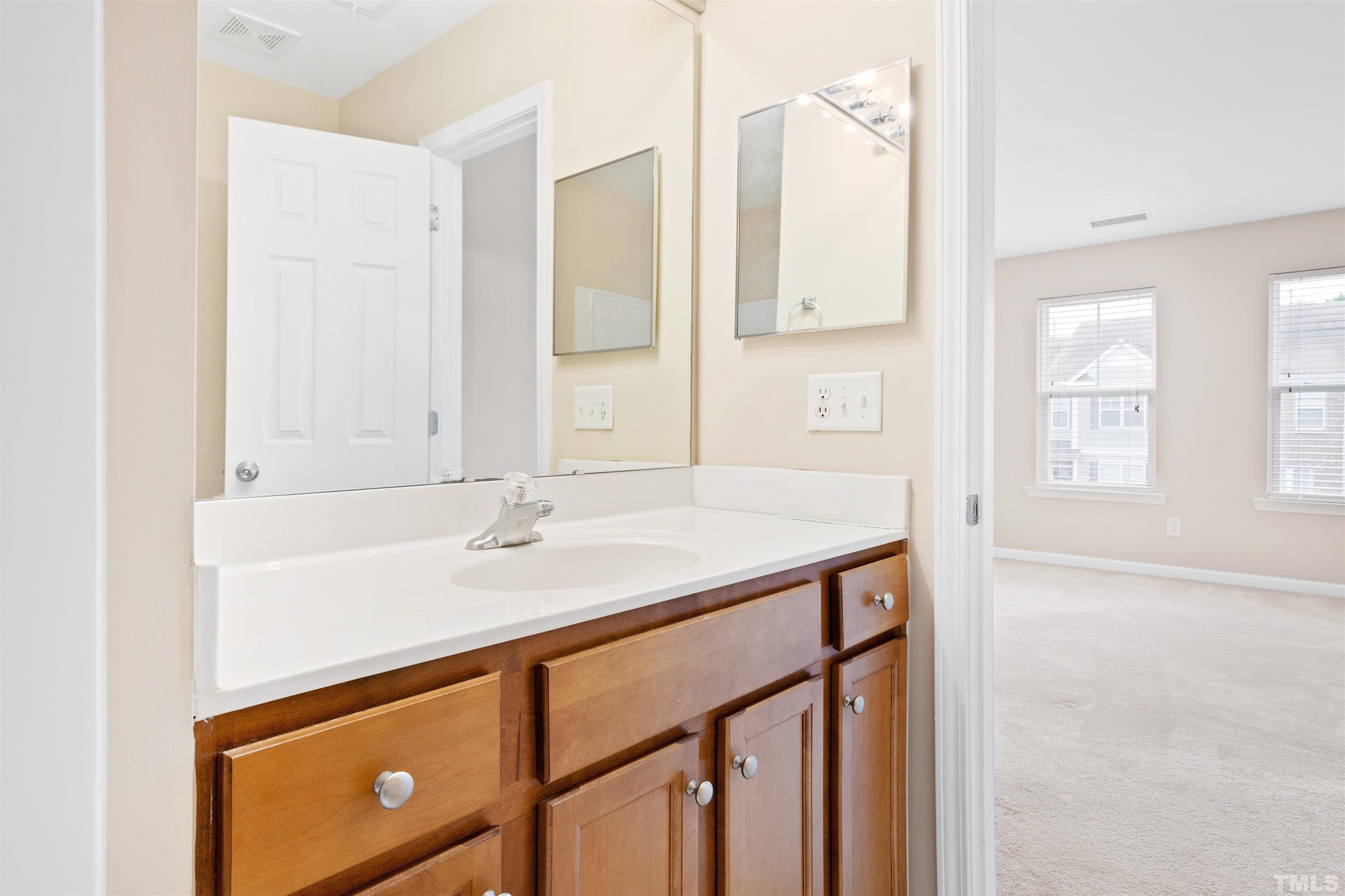 2962 Casona Way Raleigh, NC 27616 - Photo 28 of 40 a bathroom with a sink and a mirror