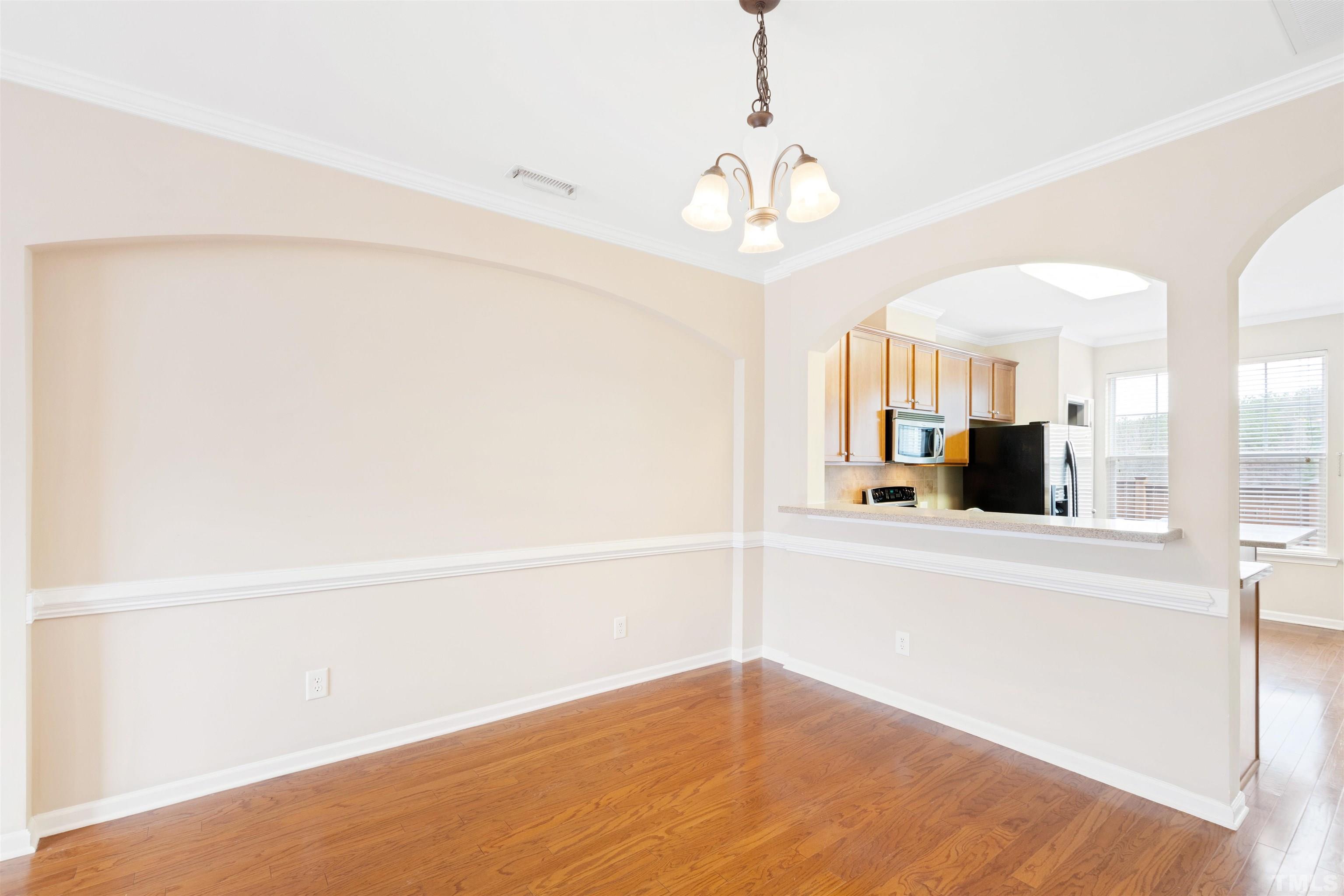 2962 Casona Way Raleigh, NC 27616 - Photo 4 of 40 a view of a kitchen with wooden floor and a refrigerator