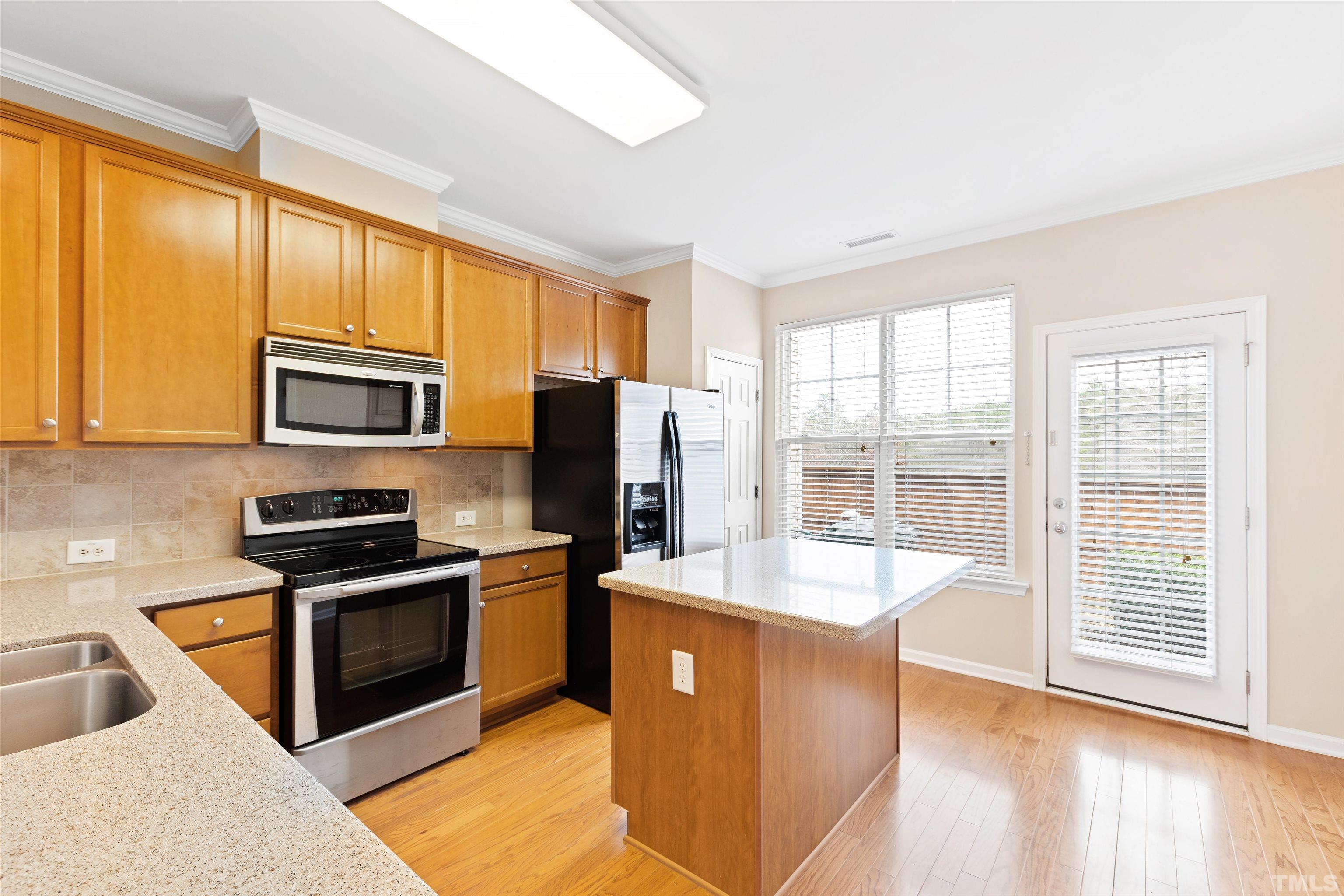 2962 Casona Way Raleigh, NC 27616 - Photo 5 of 40 a kitchen with stainless steel appliances granite countertop a stove a sink dishwasher a refrigerator and a microwave