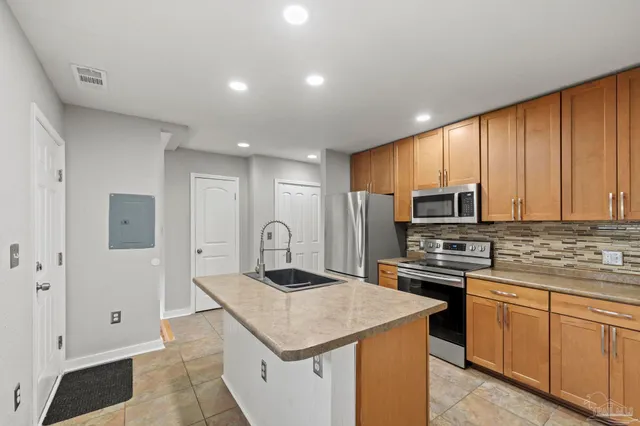 a kitchen with stainless steel appliances granite countertop a stove a sink dishwasher a refrigerator and a microwave