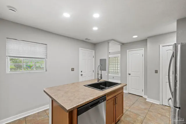 a kitchen that has a sink a stove and a refrigerator