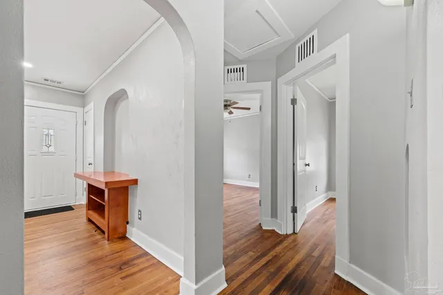 a view of a hallway with wooden floor and furniture